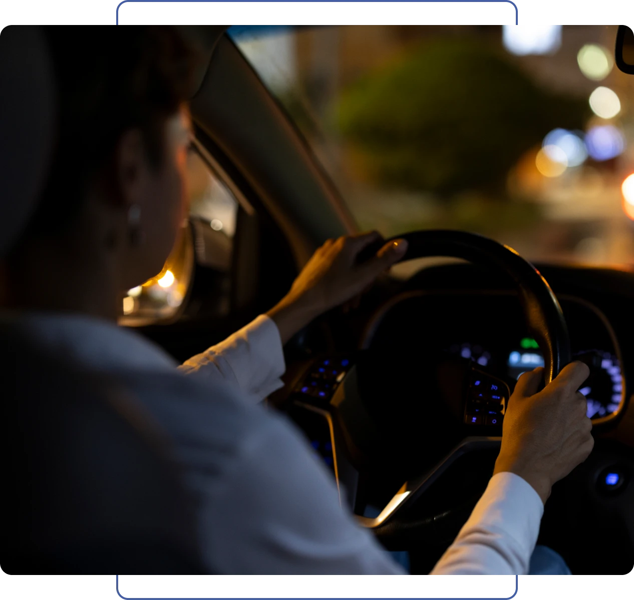 Hands on steering wheel in dark car